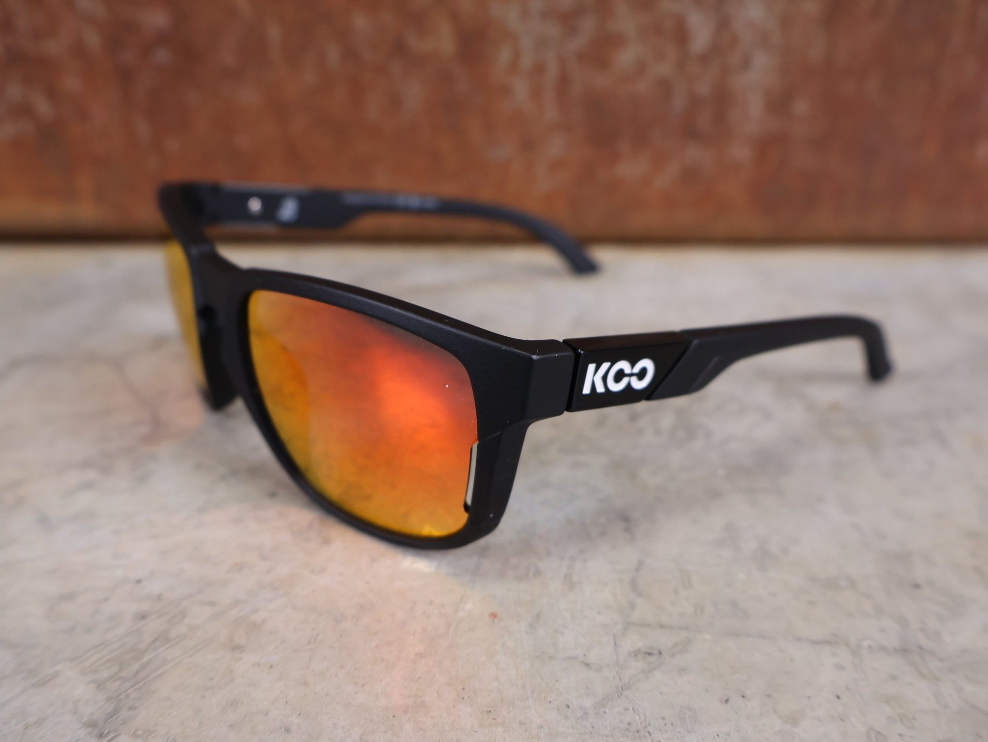 Brillen von Koo, KOO CALIFORNIA BRILLE – SCHWARZ MATT / RED MIRROR – RED BULL – BORA – HANSGROHE EDITION vor USEDBIKES - OB.DE Hintergrund