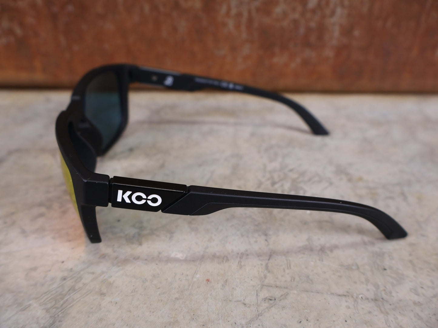 Brillen von Koo, KOO CALIFORNIA BRILLE – SCHWARZ MATT / RED MIRROR – RED BULL – BORA – HANSGROHE EDITION vor USEDBIKES - OB.DE Hintergrund