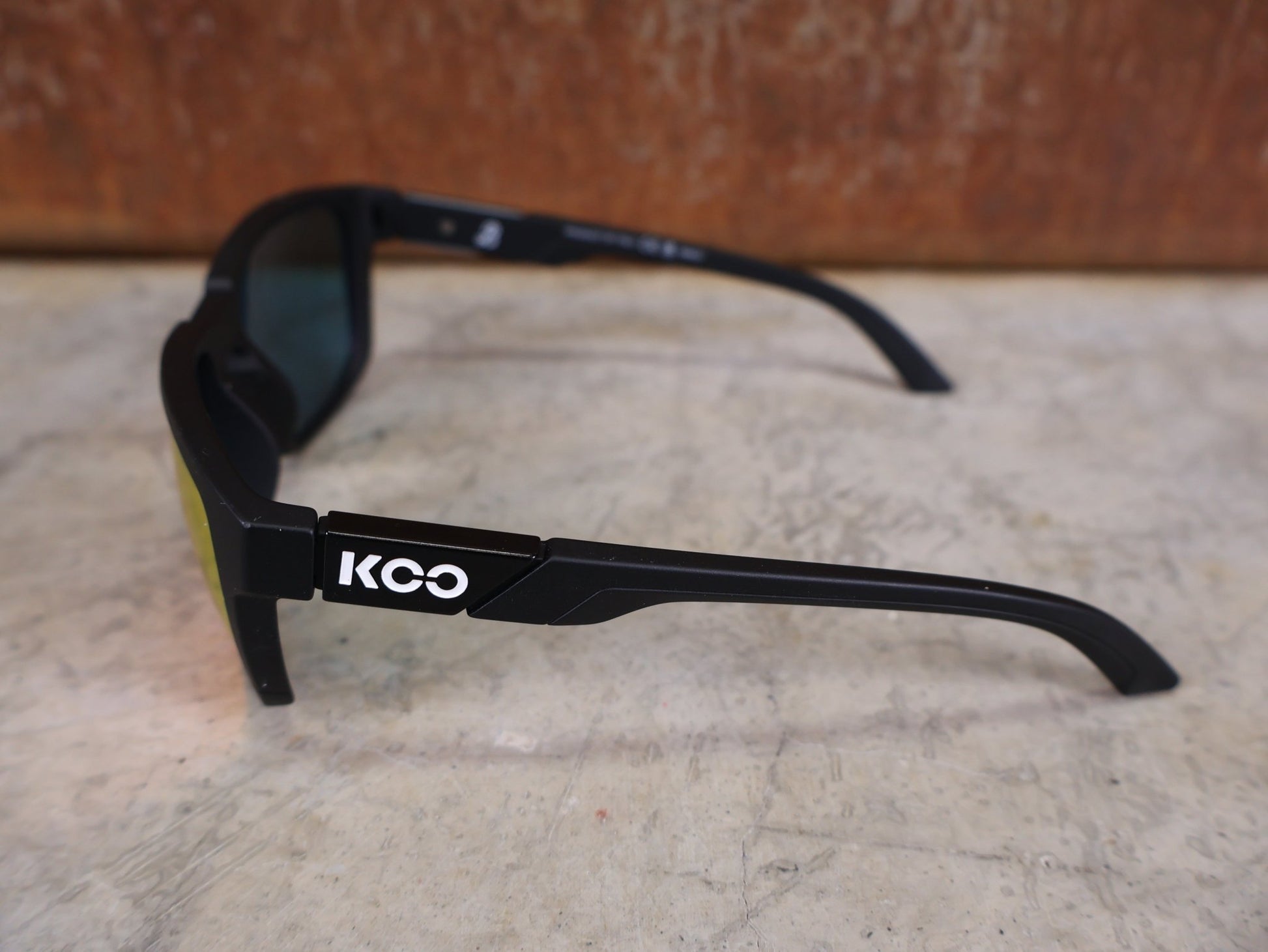 Brillen von Koo, KOO CALIFORNIA BRILLE – SCHWARZ MATT / RED MIRROR – RED BULL – BORA – HANSGROHE EDITION vor USEDBIKES - OB.DE Hintergrund