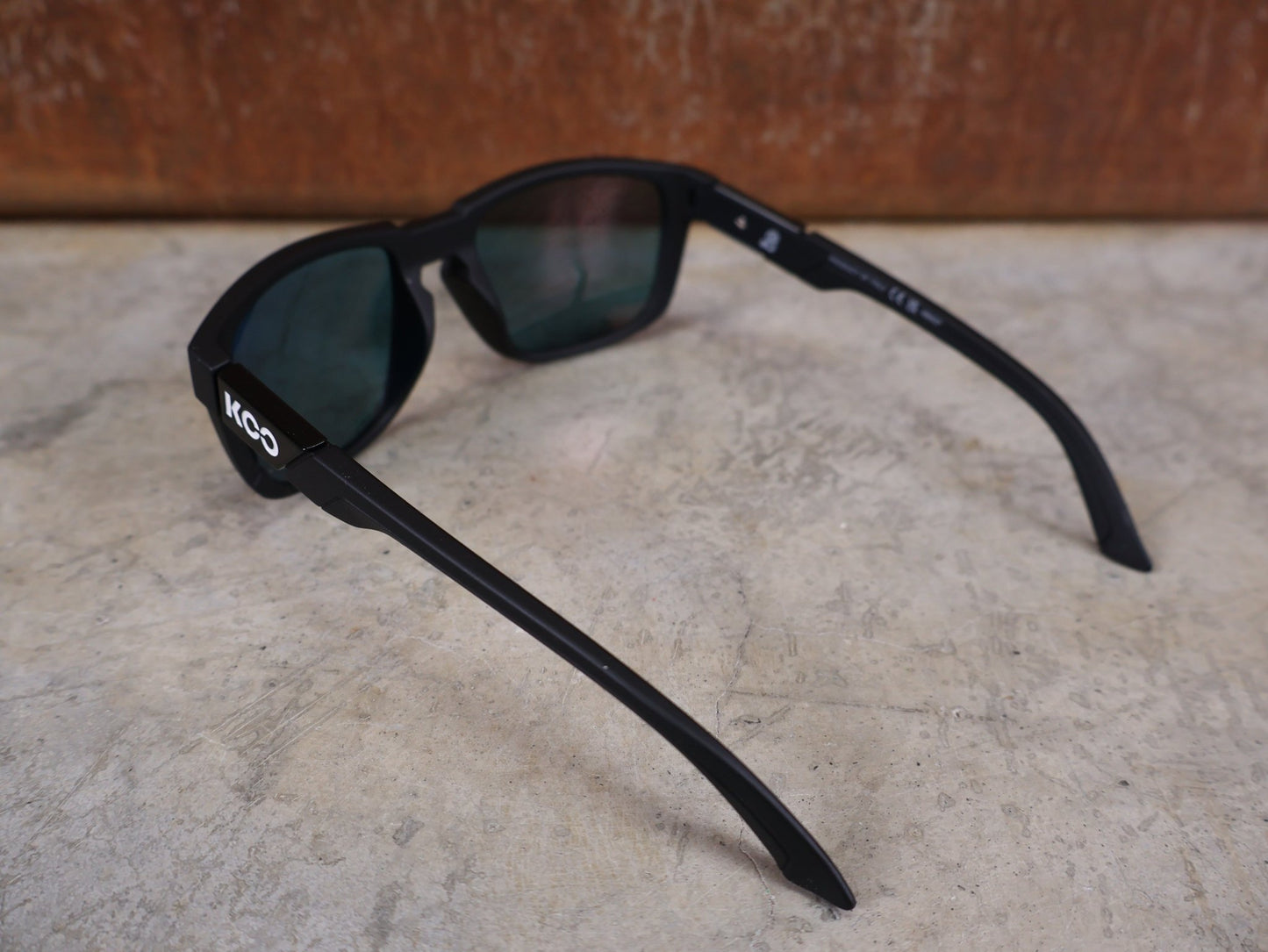 Brillen von Koo, KOO CALIFORNIA BRILLE – SCHWARZ MATT / RED MIRROR – RED BULL – BORA – HANSGROHE EDITION vor USEDBIKES - OB.DE Hintergrund