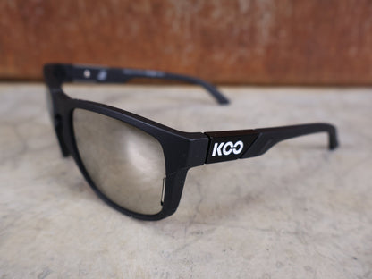 Brillen von Koo, KOO CALIFORNIA BRILLE – SCHWARZ MATT / SUPER SILVER – RED BULL – BORA – HANSGROHE EDITION vor USEDBIKES - OB.DE Hintergrund
