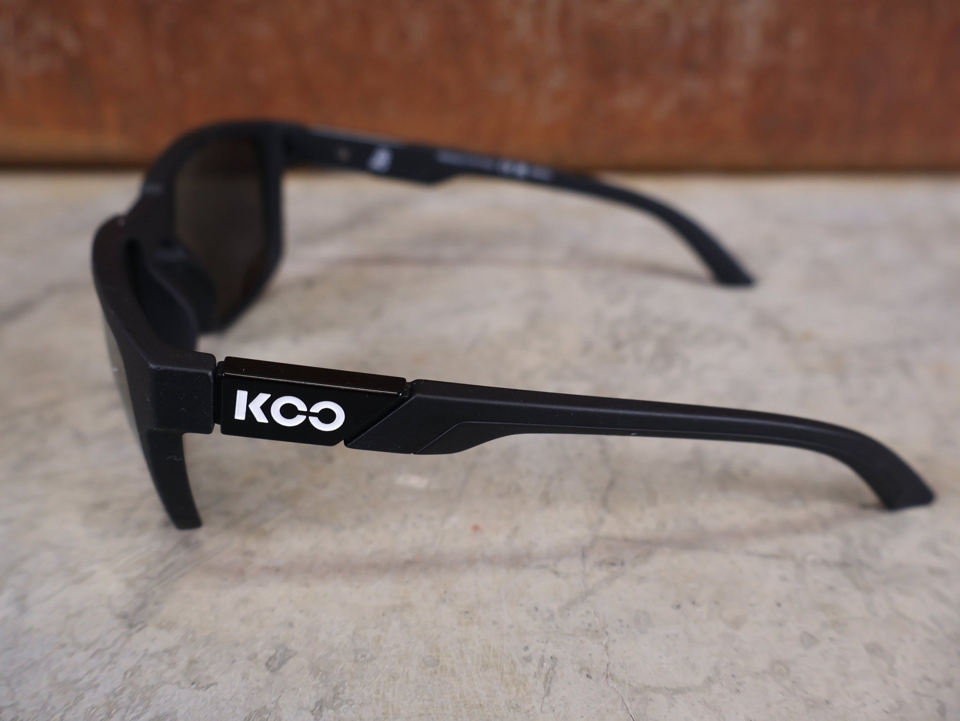 Brillen von Koo, KOO CALIFORNIA BRILLE – SCHWARZ MATT / SUPER SILVER – RED BULL – BORA – HANSGROHE EDITION vor USEDBIKES - OB.DE Hintergrund