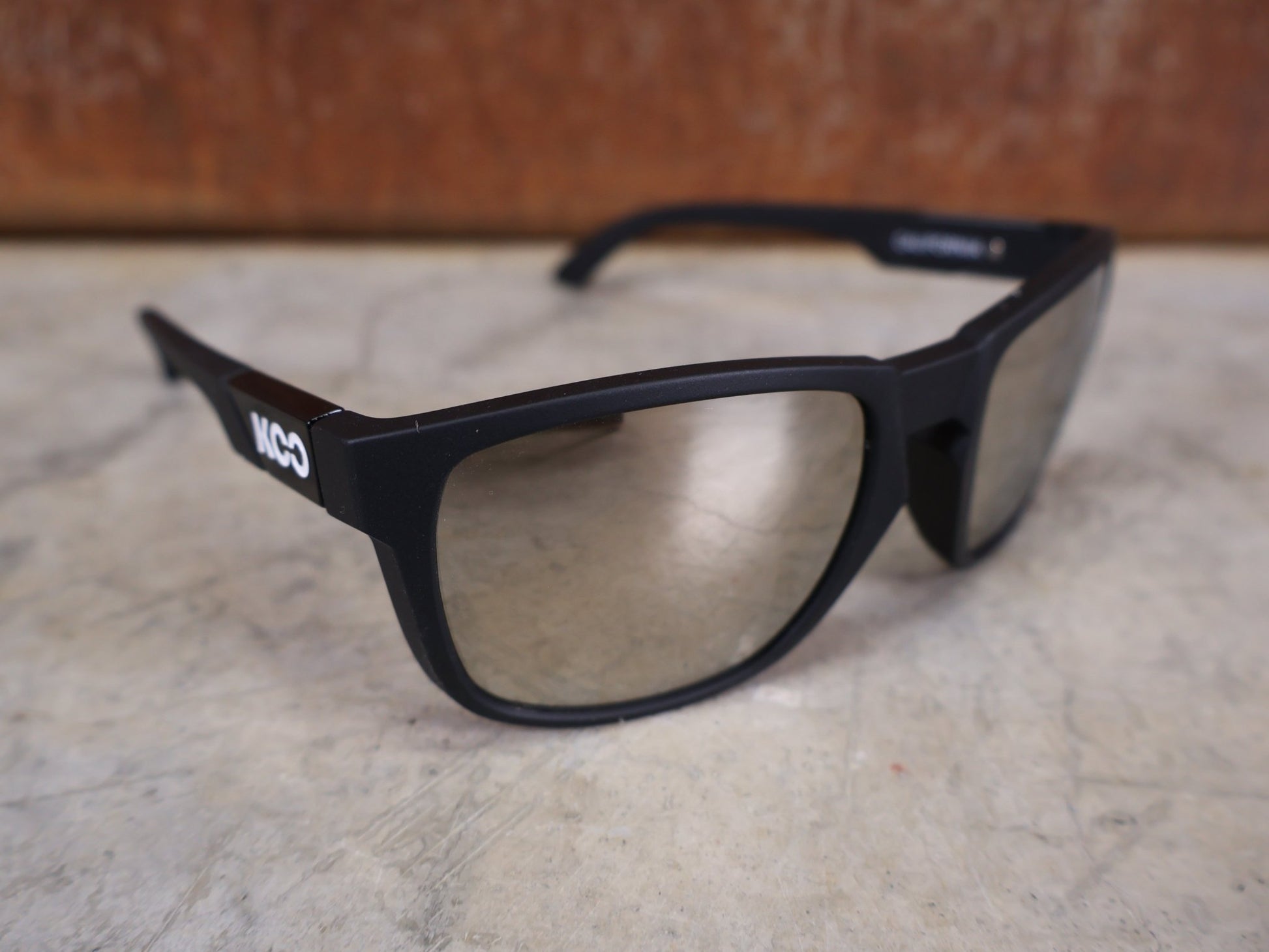 Brillen von Koo, KOO CALIFORNIA BRILLE – SCHWARZ MATT / SUPER SILVER – RED BULL – BORA – HANSGROHE EDITION vor USEDBIKES - OB.DE Hintergrund