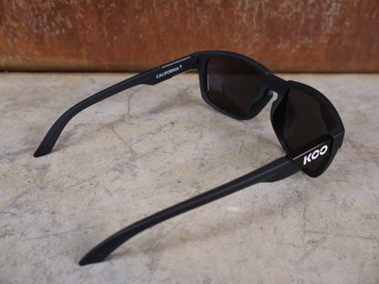 Brillen von Koo, KOO CALIFORNIA BRILLE – SCHWARZ MATT / SUPER SILVER – RED BULL – BORA – HANSGROHE EDITION vor USEDBIKES - OB.DE Hintergrund