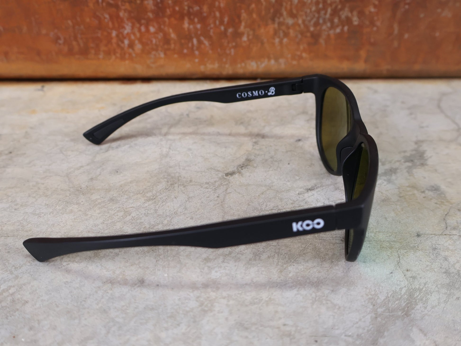 Brillen von Koo, KOO COSMO BRILLE – SCHWARZ MATT / GREEN MIRROR – RED BULL – BORA – HANSGROHE EDITION vor USEDBIKES - OB.DE Hintergrund