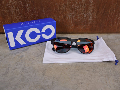 Brillen von Koo, KOO COSMO BRILLE – SCHWARZ MATT / RED MIRROR – RED BULL – BORA – HANSGROHE EDITION vor USEDBIKES - OB.DE Hintergrund