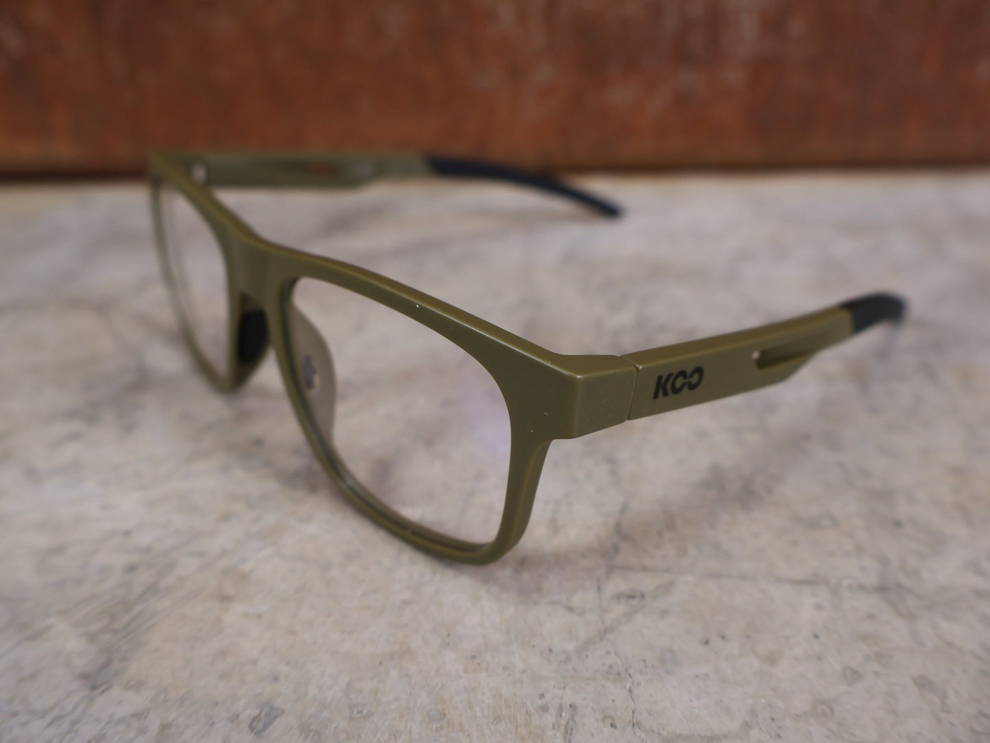 Brillen von Koo, KOO FIJI BRILLE – KHAKI GREEN MATT / DEMO - GLAS vor USEDBIKES - OB.DE Hintergrund