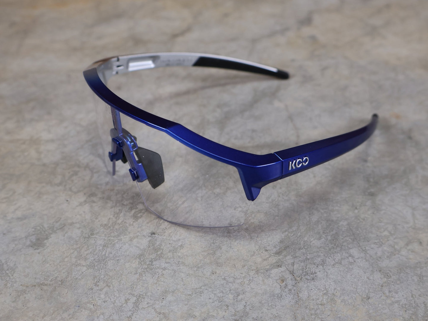 Brillen von Koo, KOO RED BULL - BORA HANSGROHE ALIBI LARGE SONNENBRILLE / CLEAR SMOKE vor USEDBIKES - OB.DE Hintergrund