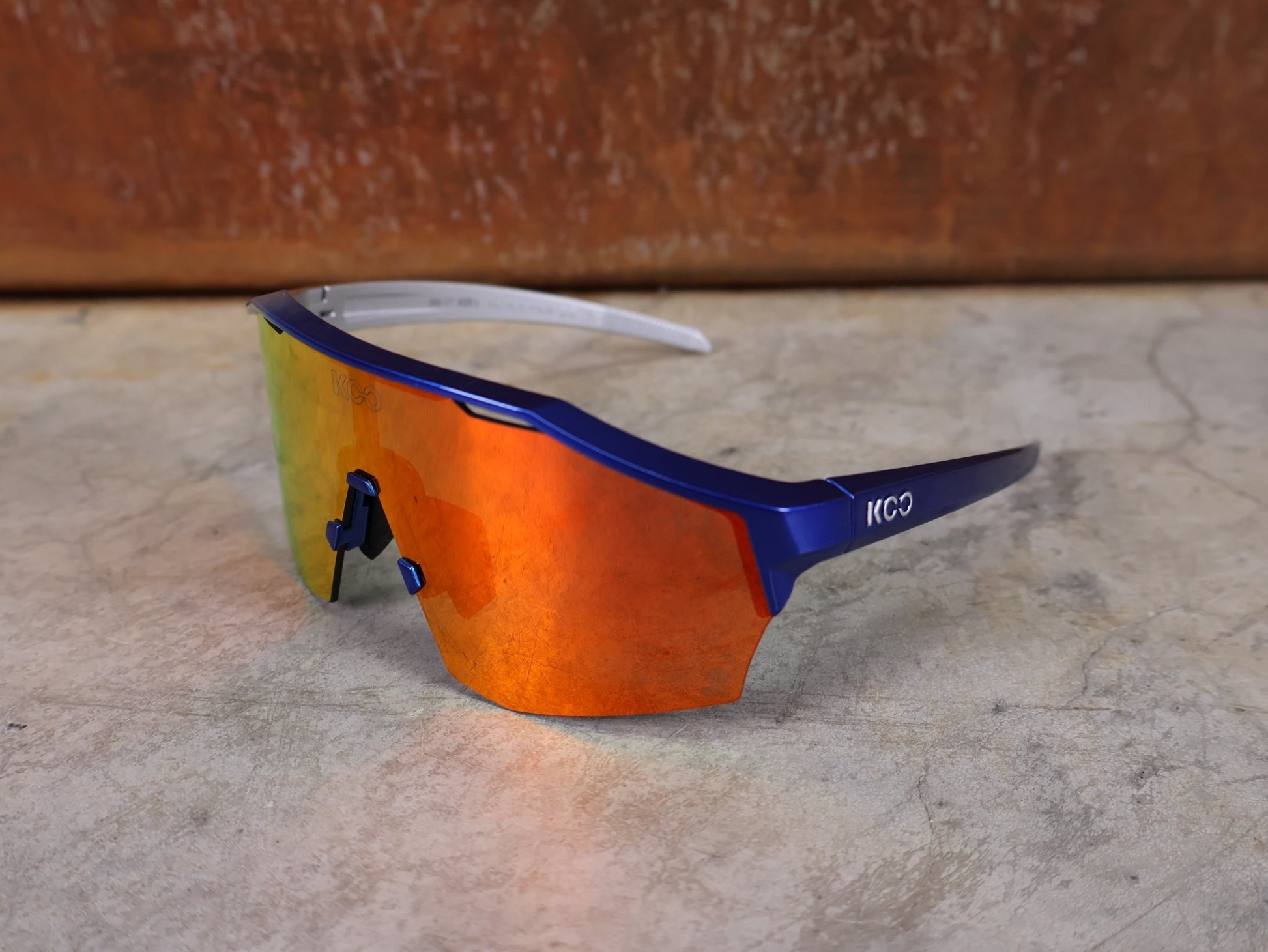 Brillen von Koo, KOO RED BULL - BORA HANSGROHE ALIBI LARGE SONNENBRILLE / RED MIRROR vor USEDBIKES - OB.DE Hintergrund