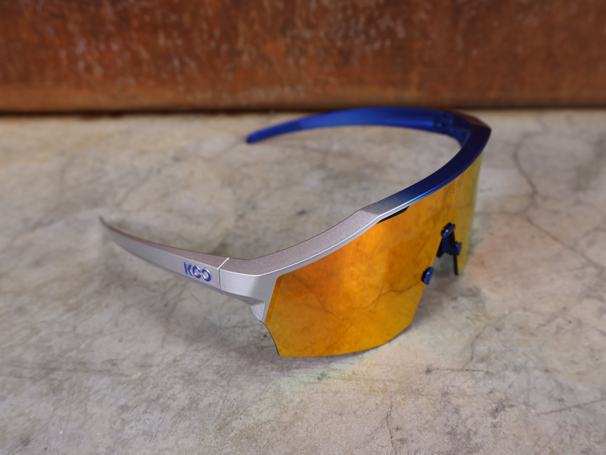 Brillen von Koo, KOO RED BULL - BORA HANSGROHE ALIBI LARGE SONNENBRILLE / RED MIRROR vor USEDBIKES - OB.DE Hintergrund