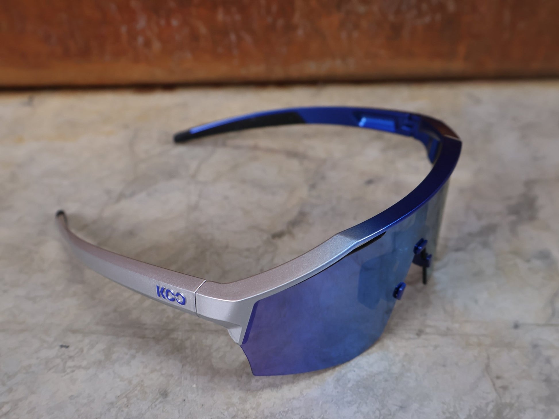 Brillen von Koo, KOO RED BULL - BORA HANSGROHE ALIBI LARGE SONNENBRILLE / TURQUOISE MIRROR vor USEDBIKES - OB.DE Hintergrund