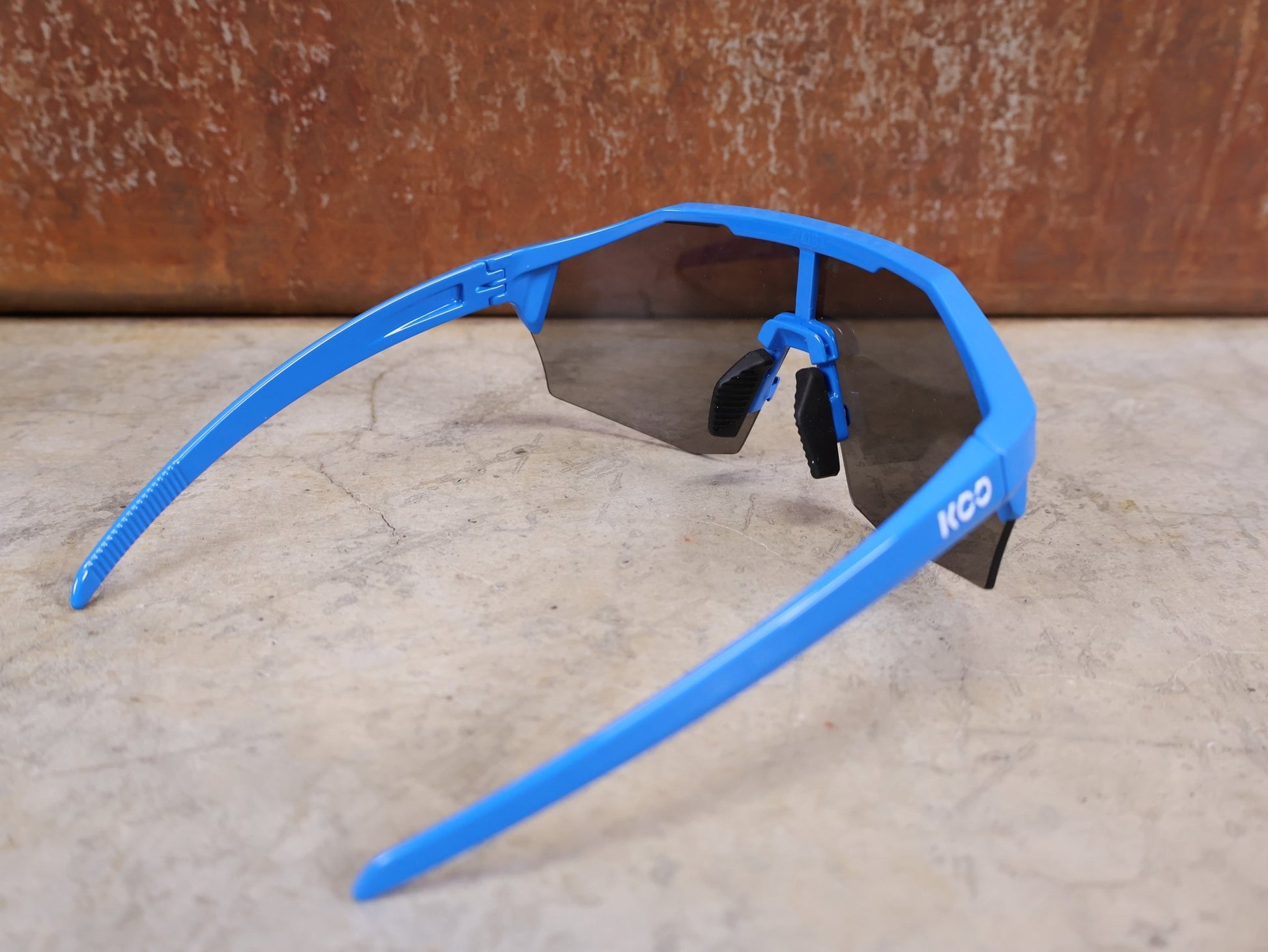 Brillen von Koo, KOO RED BULL - BORA HANSGROHE ALIBI PRO SONNENBRILLE / BLUE JERSEY vor USEDBIKES - OB.DE Hintergrund