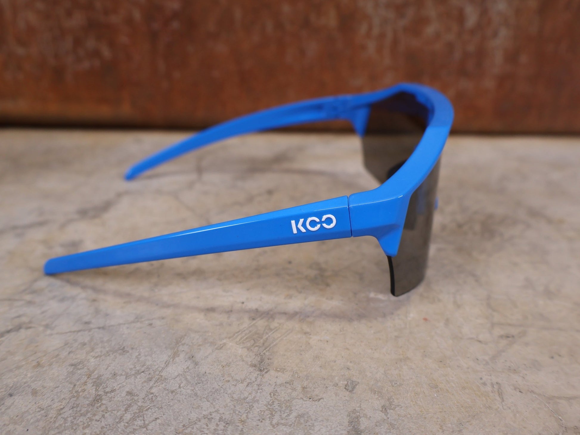 Brillen von Koo, KOO RED BULL - BORA HANSGROHE ALIBI PRO SONNENBRILLE / BLUE JERSEY vor USEDBIKES - OB.DE Hintergrund