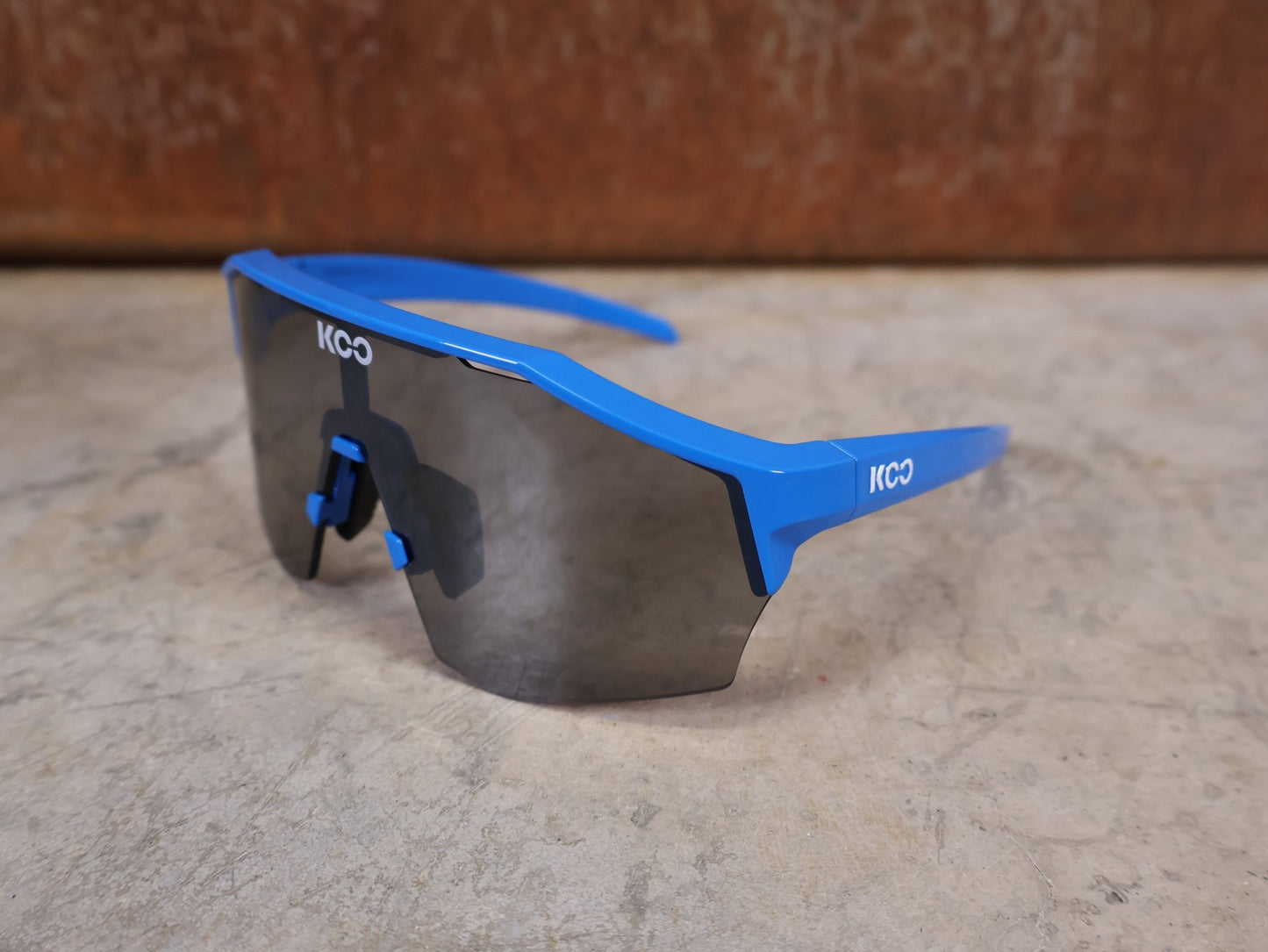 Brillen von Koo, KOO RED BULL - BORA HANSGROHE ALIBI PRO SONNENBRILLE / BLUE JERSEY vor USEDBIKES - OB.DE Hintergrund