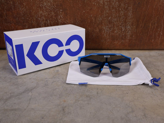 Brillen von Koo, KOO RED BULL - BORA HANSGROHE ALIBI PRO SONNENBRILLE / BLUE JERSEY vor USEDBIKES - OB.DE Hintergrund