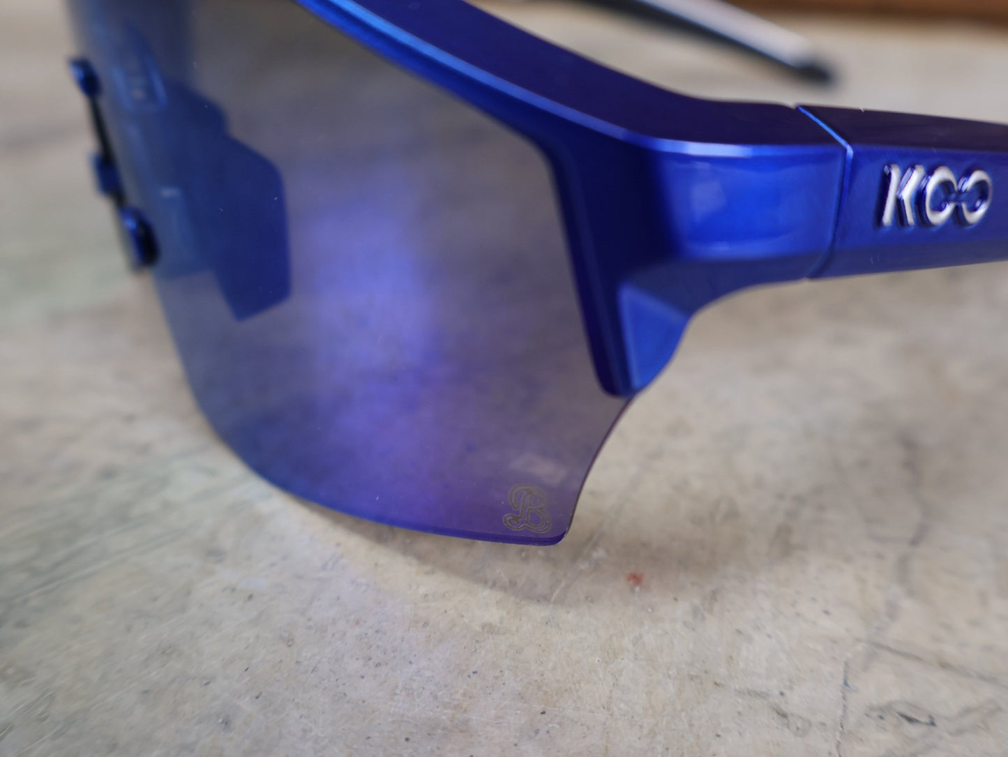 Brillen von Koo, KOO RED BULL - BORA HANSGROHE ALIBI PRO SONNENBRILLE / GREEN MIRROR vor USEDBIKES - OB.DE Hintergrund