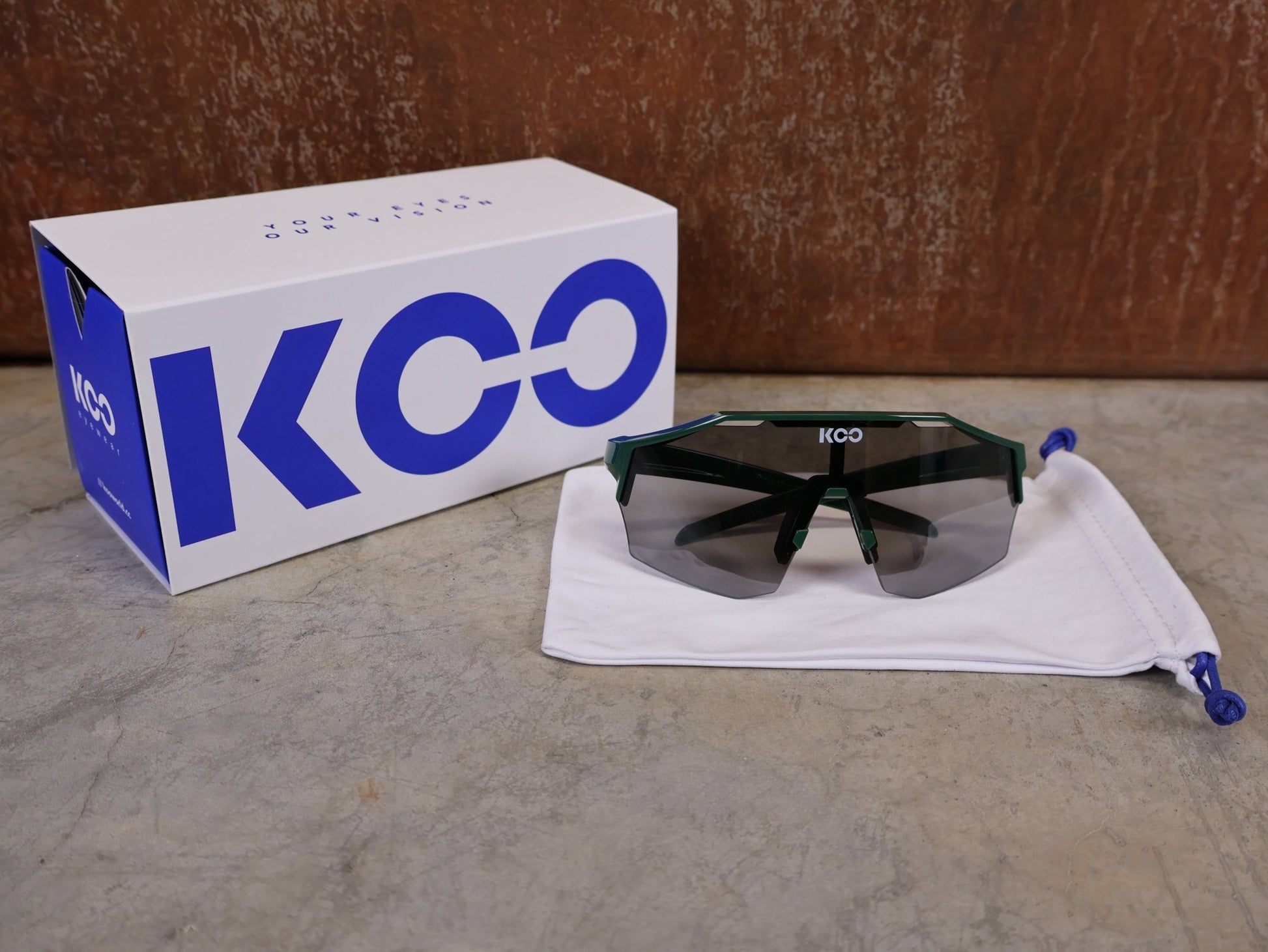 Brillen von Koo, KOO RED BULL - BORA HANSGROHE ALIBI PRO SONNENBRILLE / TOUR DE FRANCE GRÜN vor USEDBIKES - OB.DE Hintergrund