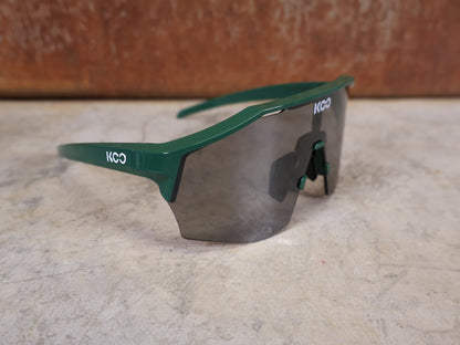 Brillen von Koo, KOO RED BULL - BORA HANSGROHE ALIBI PRO SONNENBRILLE / TOUR DE FRANCE GRÜN vor USEDBIKES - OB.DE Hintergrund