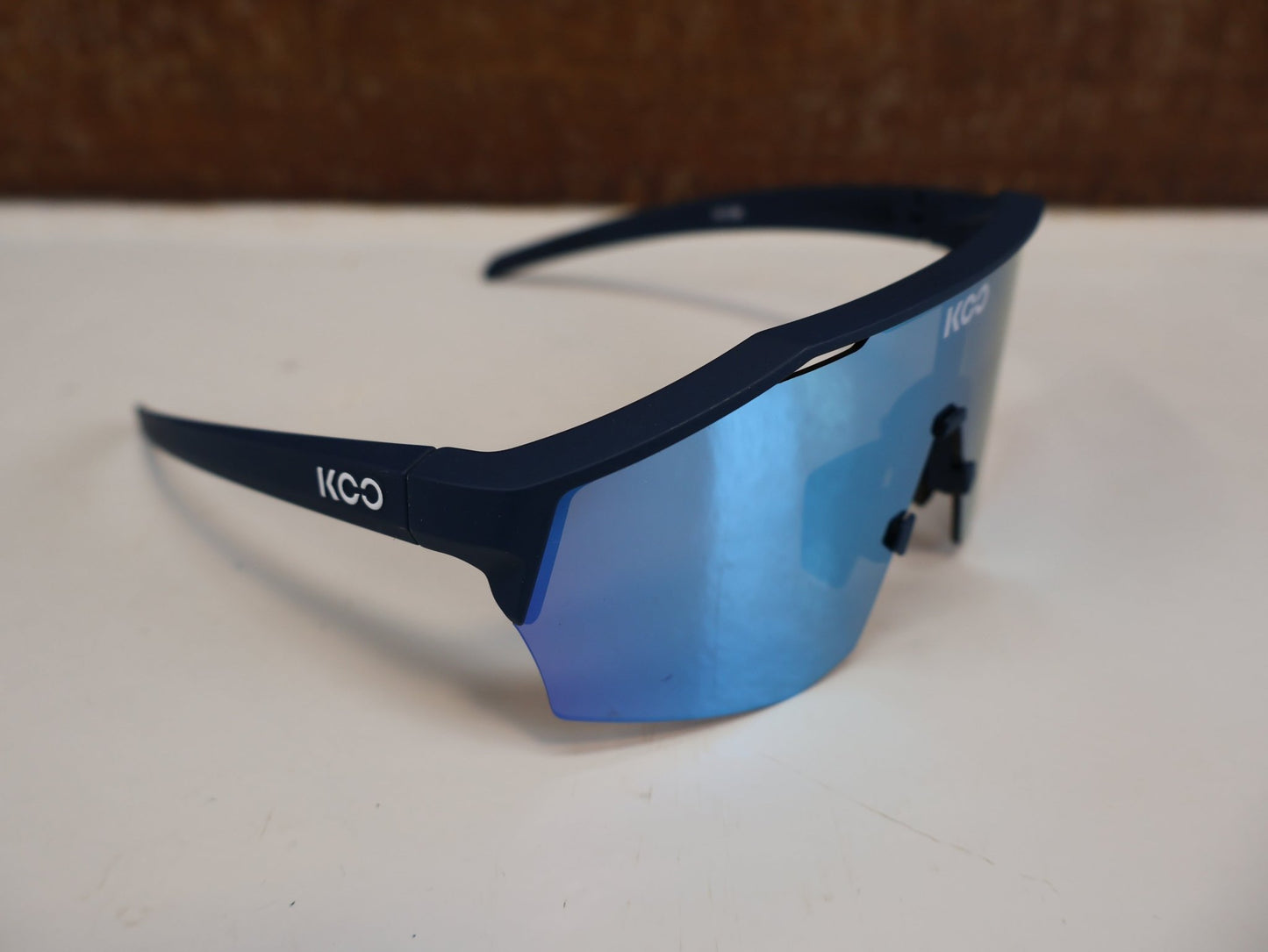 Brillen von Koo, KOO RED BULL - BORA HANSGROHE ALIBI SONNENBRILLE / BLAU MATT vor USEDBIKES - OB.DE Hintergrund