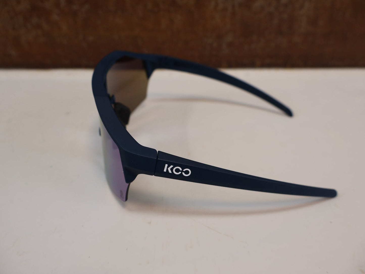 Brillen von Koo, KOO RED BULL - BORA HANSGROHE ALIBI SONNENBRILLE / BLAU MATT vor USEDBIKES - OB.DE Hintergrund
