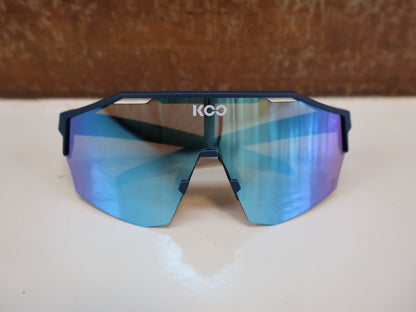 Brillen von Koo, KOO RED BULL - BORA HANSGROHE ALIBI SONNENBRILLE / BLAU MATT vor USEDBIKES - OB.DE Hintergrund