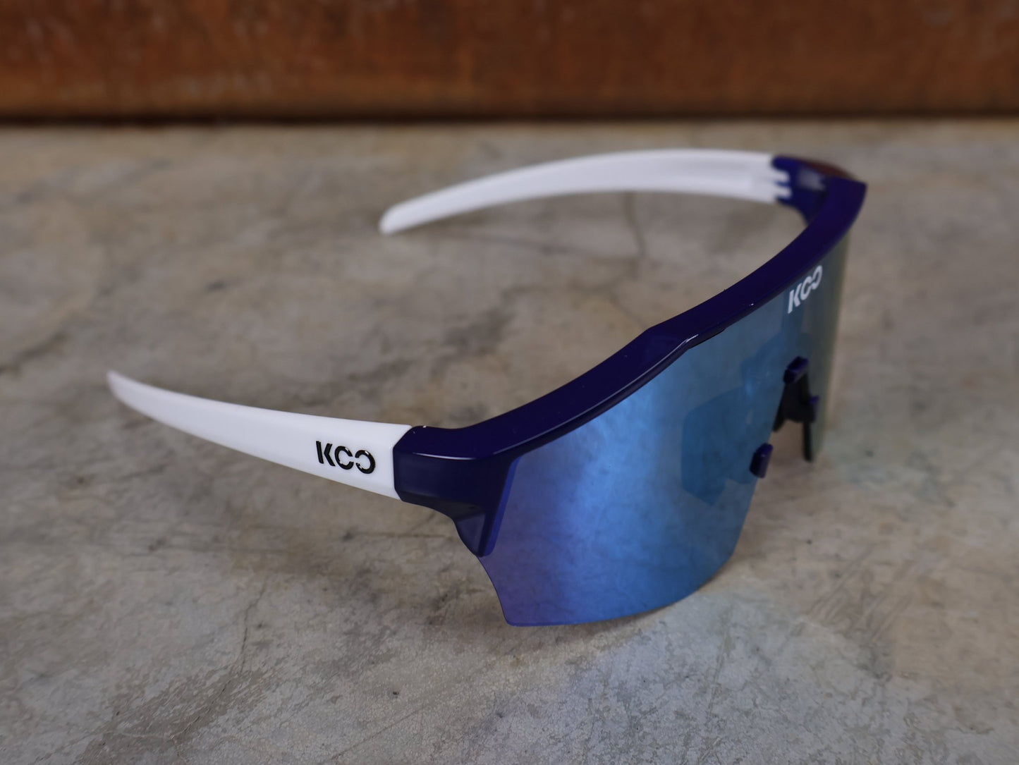 Brillen von Koo, KOO RED BULL - BORA HANSGROHE ALIBI SONNENBRILLE / LEADER EDITION BLAU vor USEDBIKES - OB.DE Hintergrund