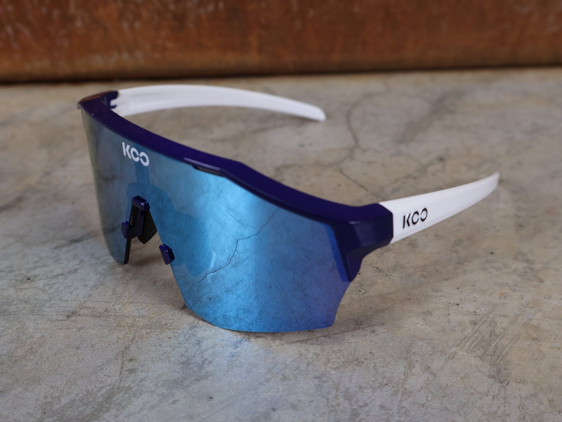 Brillen von Koo, KOO RED BULL - BORA HANSGROHE ALIBI SONNENBRILLE / LEADER EDITION BLAU vor USEDBIKES - OB.DE Hintergrund