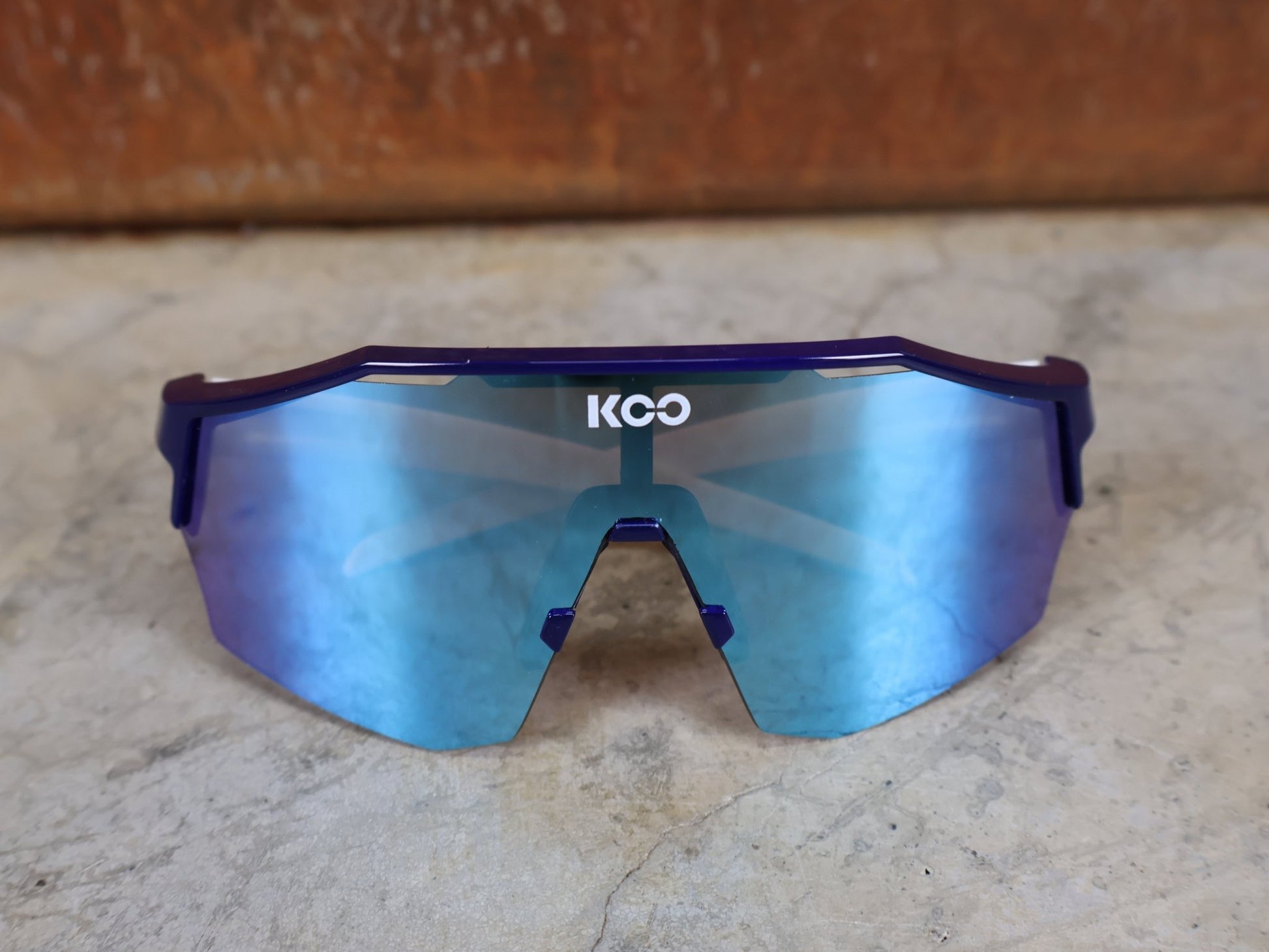 Brillen von Koo, KOO RED BULL - BORA HANSGROHE ALIBI SONNENBRILLE / LEADER EDITION BLAU vor USEDBIKES - OB.DE Hintergrund