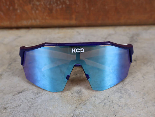 Brillen von Koo, KOO RED BULL - BORA HANSGROHE ALIBI SONNENBRILLE / LEADER EDITION BLAU vor USEDBIKES - OB.DE Hintergrund