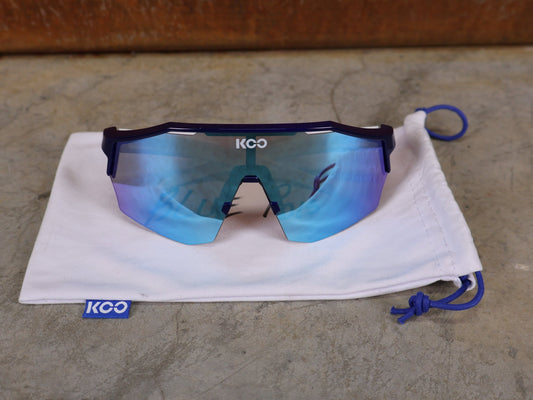Brillen von Koo, KOO RED BULL - BORA HANSGROHE ALIBI SONNENBRILLE / LEADER EDITION BLAU vor USEDBIKES - OB.DE Hintergrund