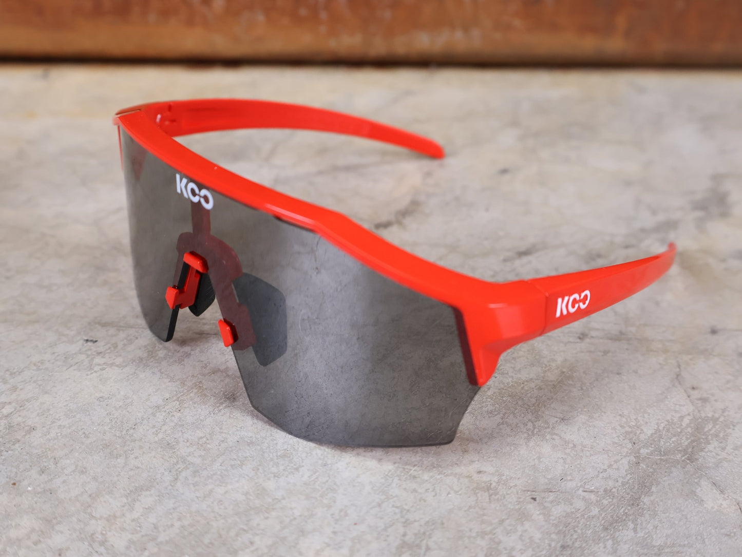 Brillen von Koo, KOO RED BULL - BORA HANSGROHE ALIBI SONNENBRILLE / LEADER EDITION ROT vor USEDBIKES - OB.DE Hintergrund