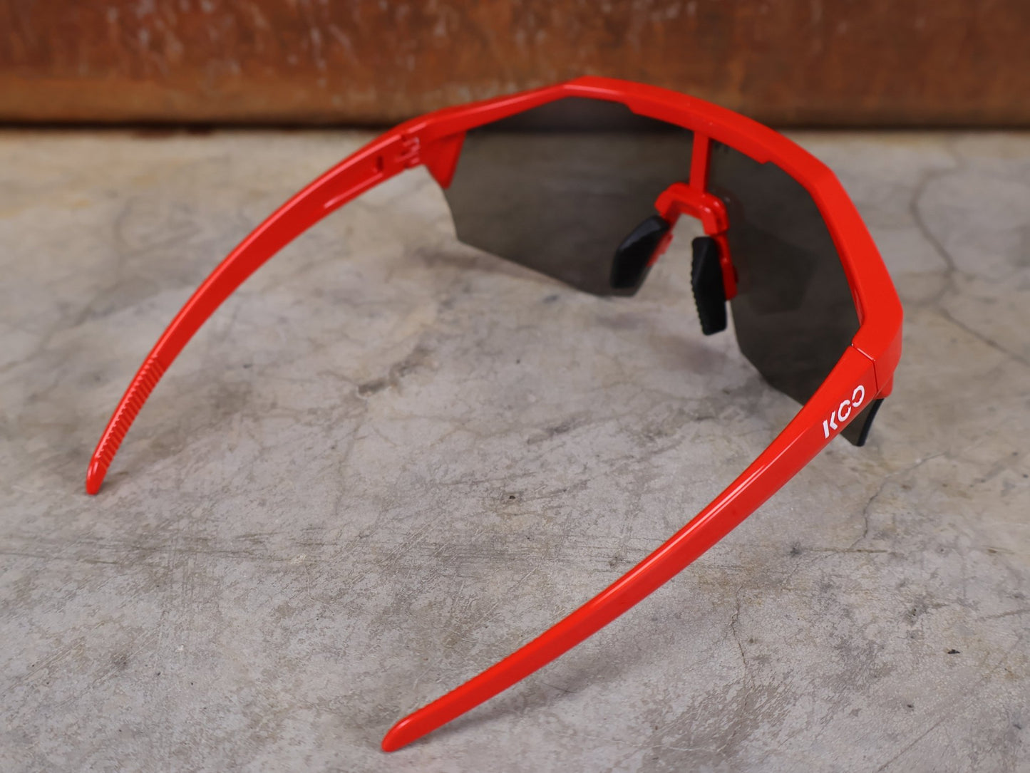 Brillen von Koo, KOO RED BULL - BORA HANSGROHE ALIBI SONNENBRILLE / LEADER EDITION ROT vor USEDBIKES - OB.DE Hintergrund