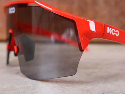Brillen von Koo, KOO RED BULL - BORA HANSGROHE ALIBI SONNENBRILLE / LEADER EDITION ROT vor USEDBIKES - OB.DE Hintergrund