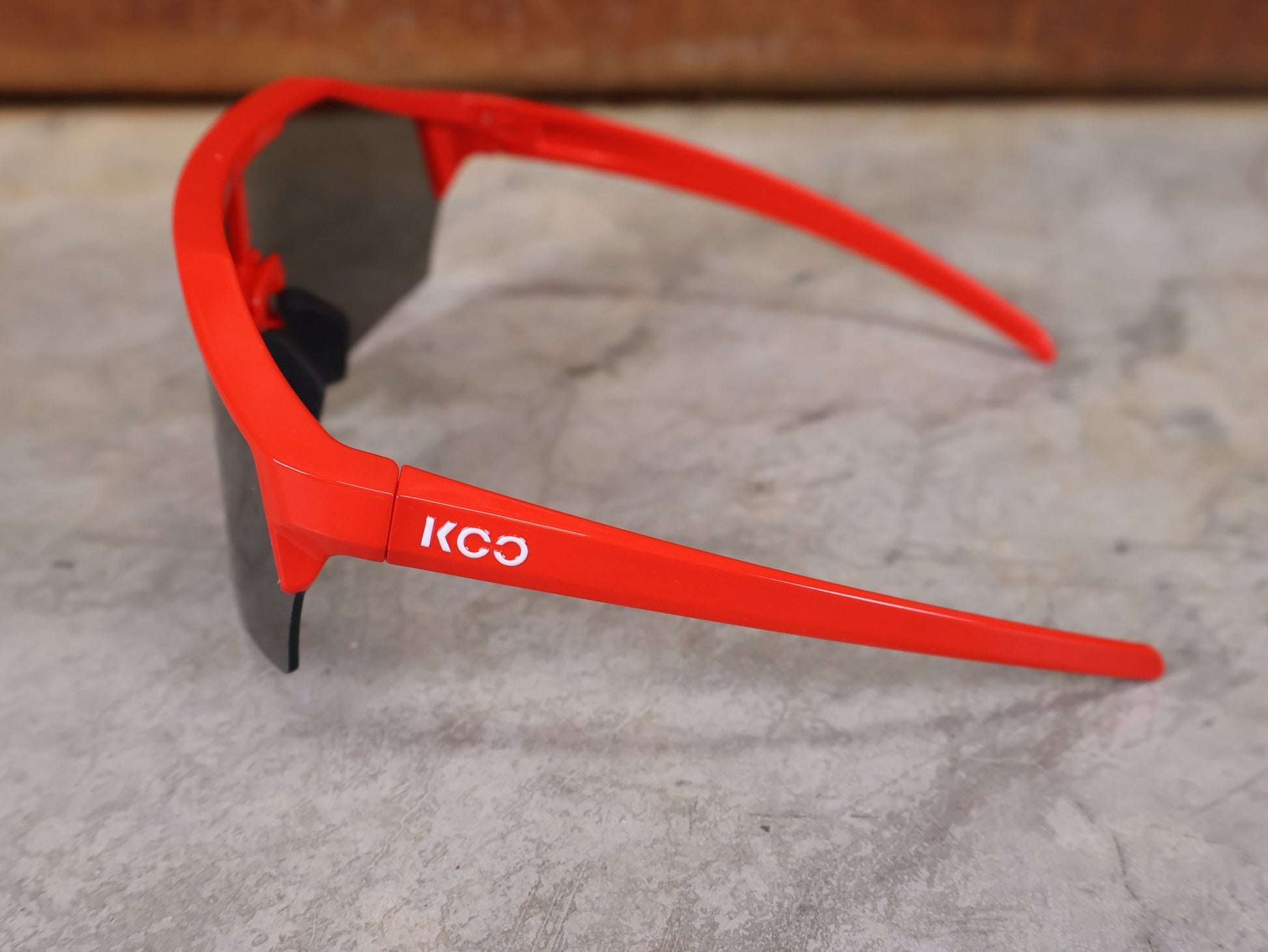 Brillen von Koo, KOO RED BULL - BORA HANSGROHE ALIBI SONNENBRILLE / LEADER EDITION ROT vor USEDBIKES - OB.DE Hintergrund
