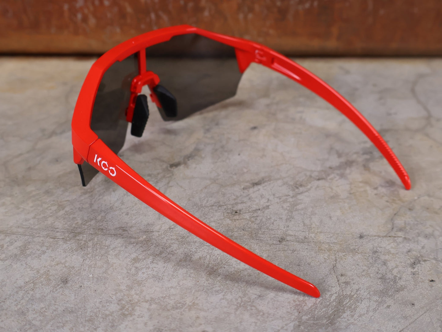 Brillen von Koo, KOO RED BULL - BORA HANSGROHE ALIBI SONNENBRILLE / LEADER EDITION ROT vor USEDBIKES - OB.DE Hintergrund