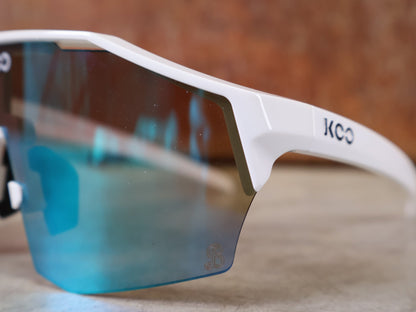 Brillen von Koo, KOO RED BULL - BORA HANSGROHE ALIBI SONNENBRILLE / LEADER EDITION WEIß vor USEDBIKES - OB.DE Hintergrund