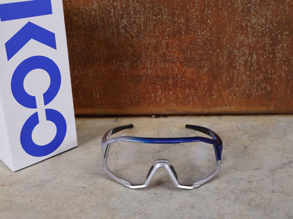 Brillen von Koo, KOO RED BULL - BORA HANSGROHE DEMOS SONNENBRILLE / CLEAR SMOKE vor USEDBIKES - OB.DE Hintergrund