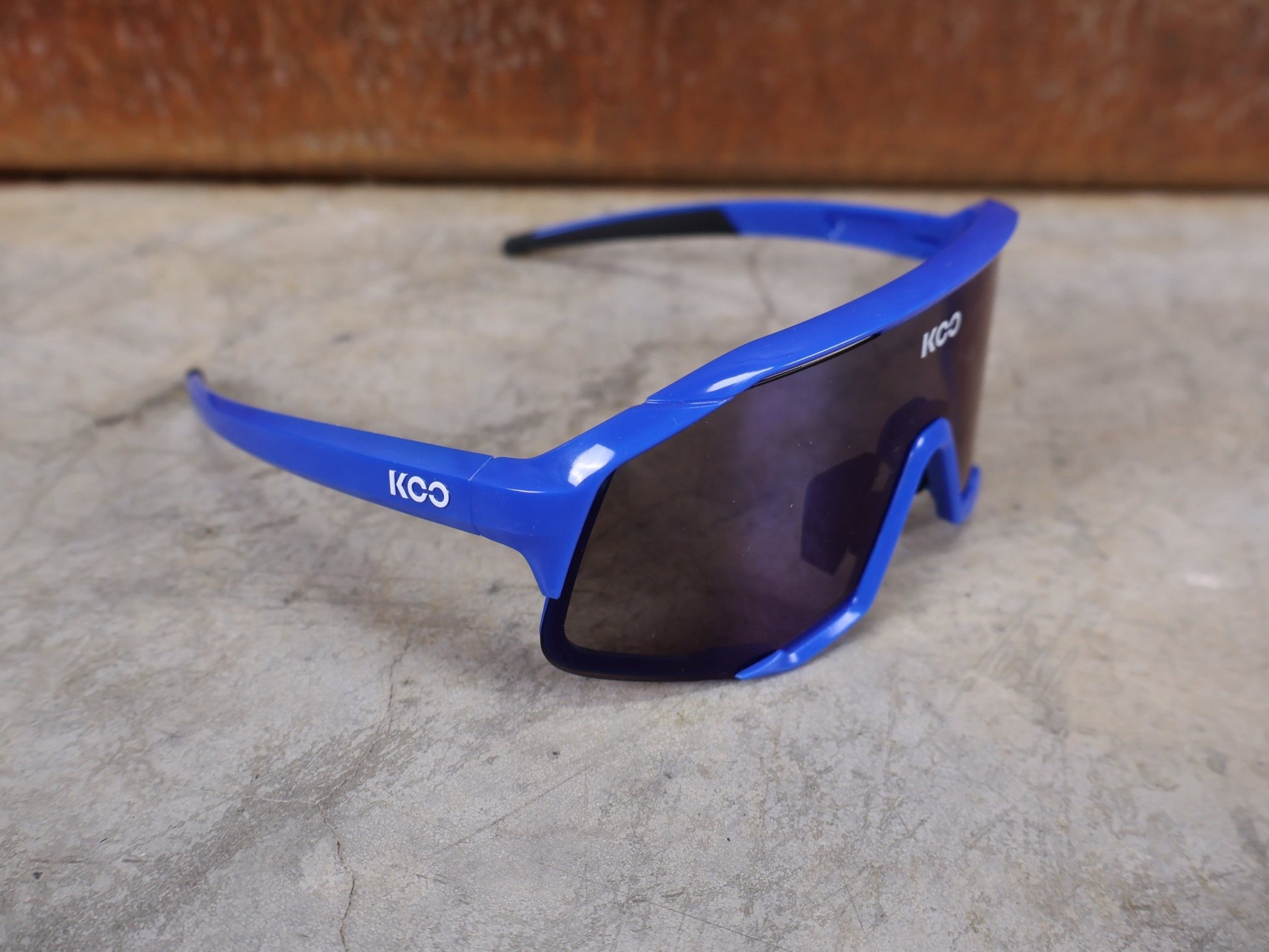 Brillen von Koo, KOO RED BULL - BORA HANSGROHE DEMOS SONNENBRILLE / LEADER EDITION BLAU vor USEDBIKES - OB.DE Hintergrund