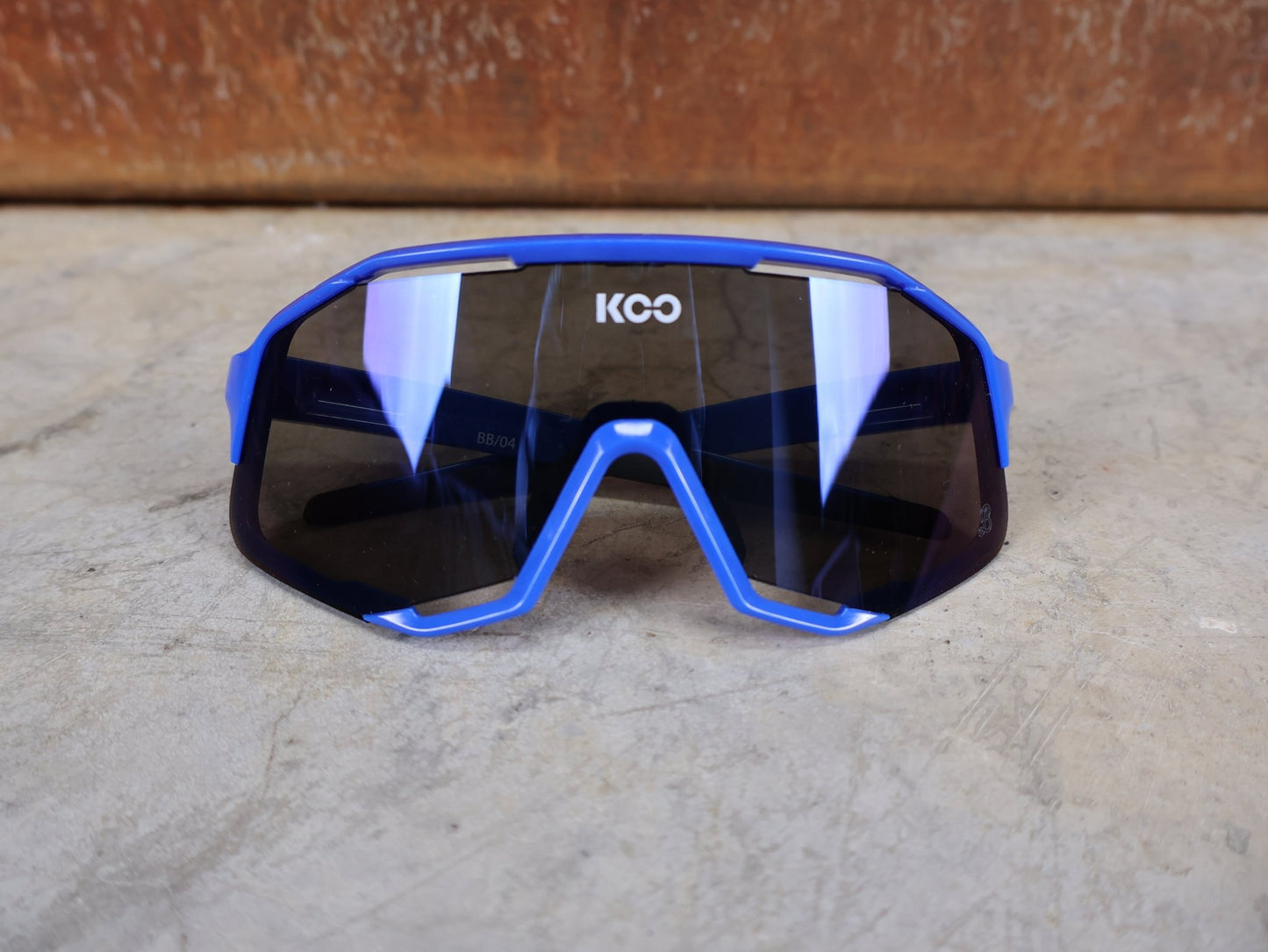 Brillen von Koo, KOO RED BULL - BORA HANSGROHE DEMOS SONNENBRILLE / LEADER EDITION BLAU vor USEDBIKES - OB.DE Hintergrund