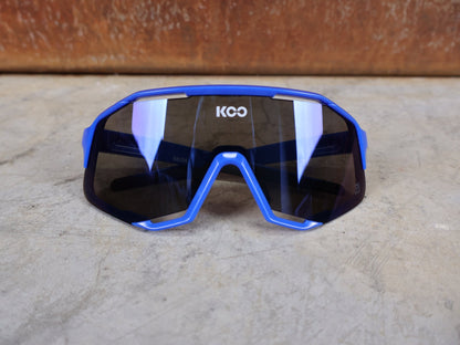 Brillen von Koo, KOO RED BULL - BORA HANSGROHE DEMOS SONNENBRILLE / LEADER EDITION BLAU vor USEDBIKES - OB.DE Hintergrund