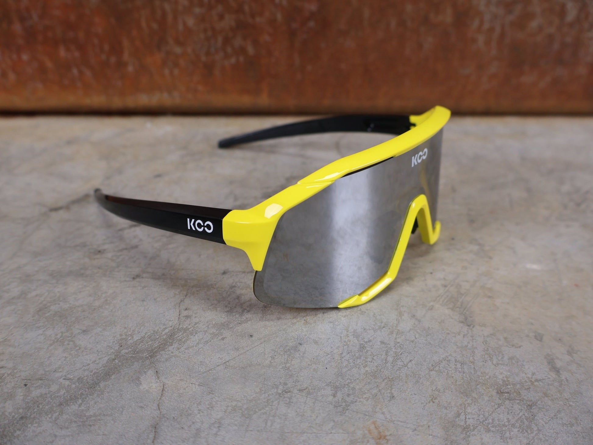 Brillen von Koo, KOO RED BULL - BORA HANSGROHE DEMOS SONNENBRILLE / LEADER EDITION GELB vor USEDBIKES - OB.DE Hintergrund