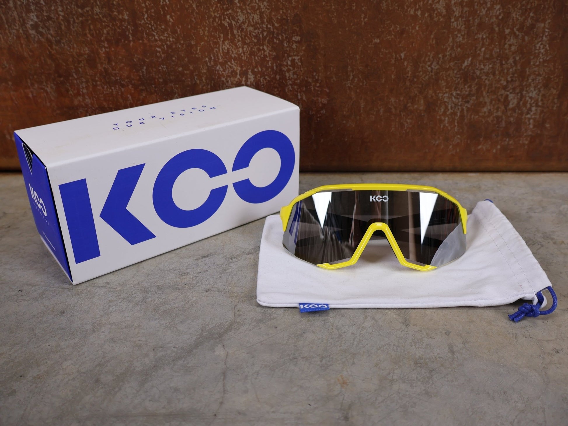 Brillen von Koo, KOO RED BULL - BORA HANSGROHE DEMOS SONNENBRILLE / LEADER EDITION GELB vor USEDBIKES - OB.DE Hintergrund