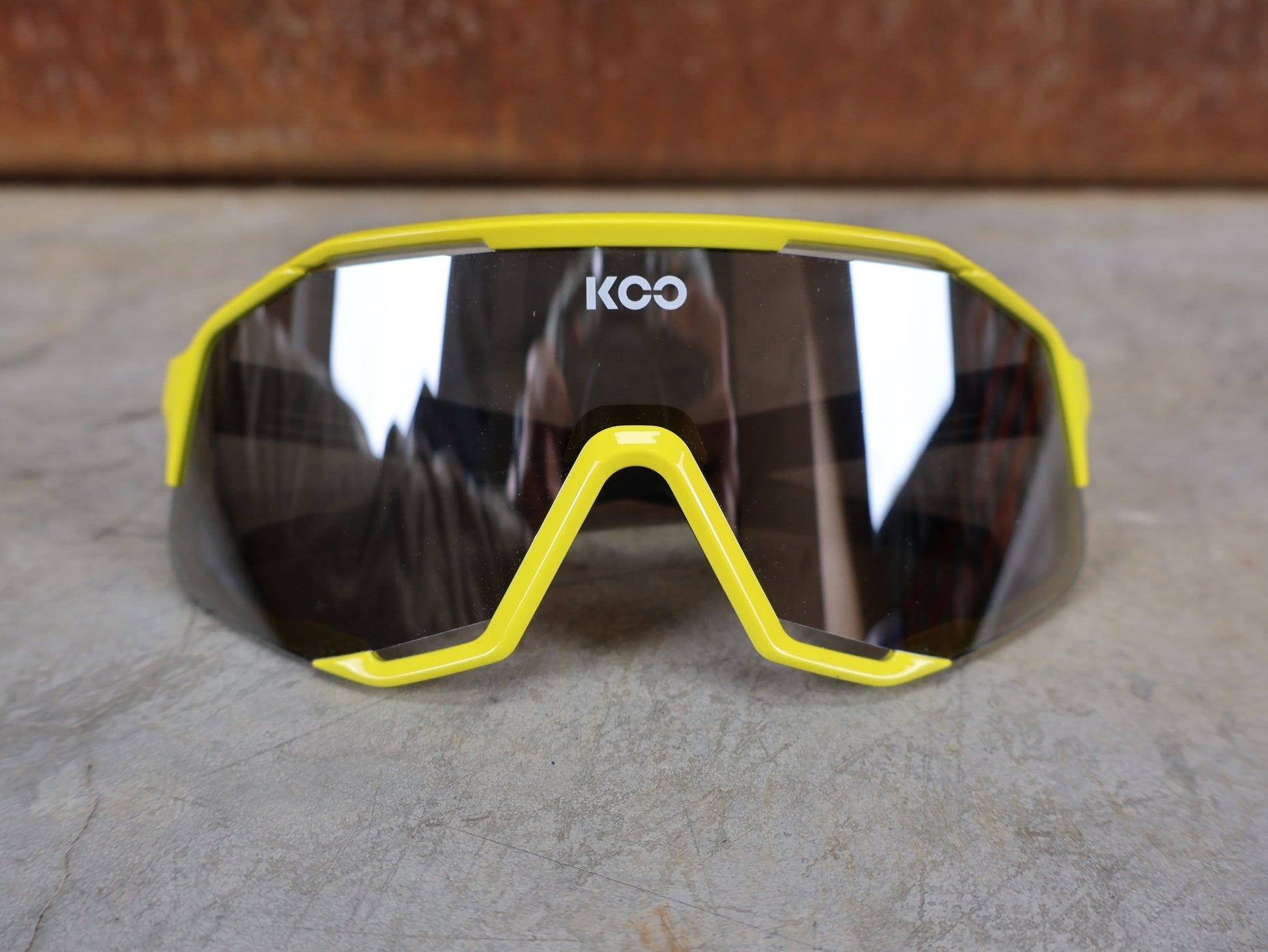 Brillen von Koo, KOO RED BULL - BORA HANSGROHE DEMOS SONNENBRILLE / LEADER EDITION GELB vor USEDBIKES - OB.DE Hintergrund