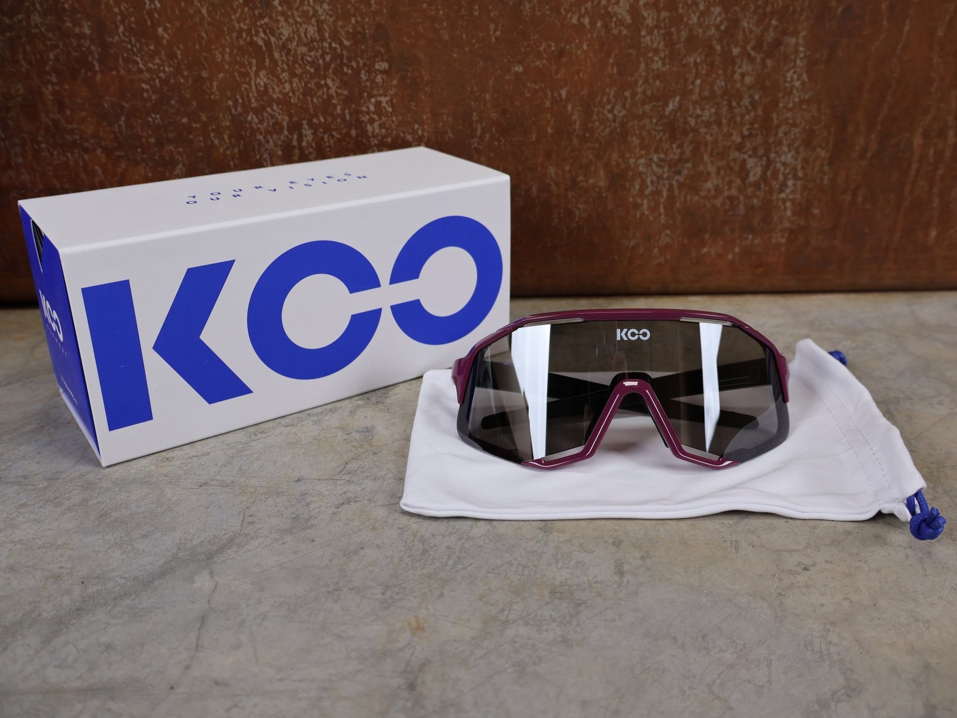 Brillen von Koo, KOO RED BULL - BORA HANSGROHE DEMOS SONNENBRILLE / MAGLIA CICLAMINO vor USEDBIKES - OB.DE Hintergrund