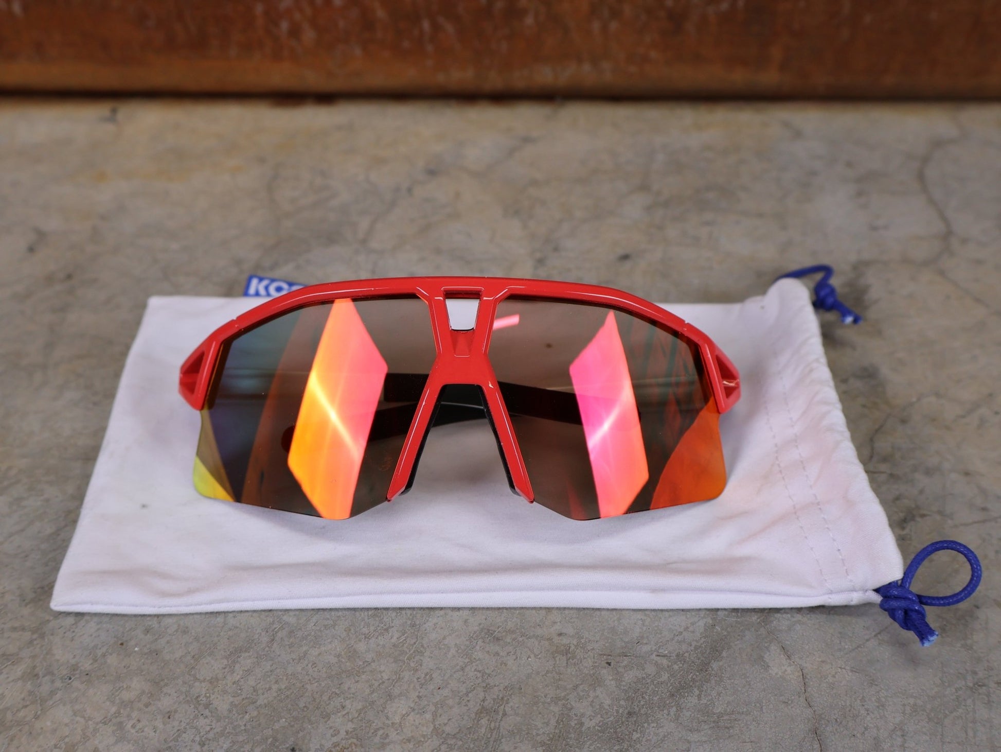 Brillen von Koo, KOO RED BULL - BORA HANSGROHE HYPE SONNENBRILLE / LEADER EDITION BERGPUNKTE vor USEDBIKES - OB.DE Hintergrund