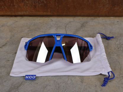 Brillen von Koo, KOO RED BULL - BORA HANSGROHE HYPE SONNENBRILLE / LEADER EDITION BLAU vor USEDBIKES - OB.DE Hintergrund