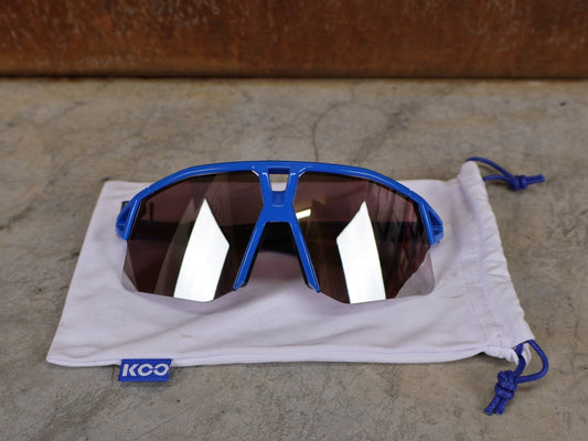 Brillen von Koo, KOO RED BULL - BORA HANSGROHE HYPE SONNENBRILLE / LEADER EDITION BLAU vor USEDBIKES - OB.DE Hintergrund