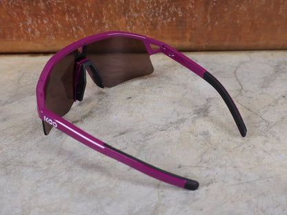 Brillen von Koo, KOO RED BULL - BORA HANSGROHE HYPE SONNENBRILLE / LEADER EDITION LILA vor USEDBIKES - OB.DE Hintergrund