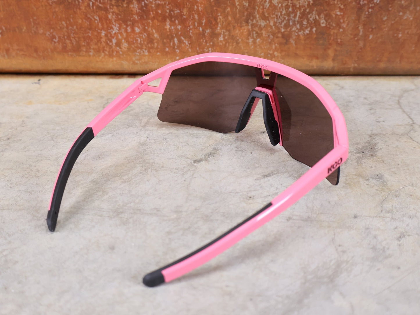 Brillen von Koo, KOO RED BULL - BORA HANSGROHE HYPE SONNENBRILLE / LEADER EDITION PINK vor USEDBIKES - OB.DE Hintergrund