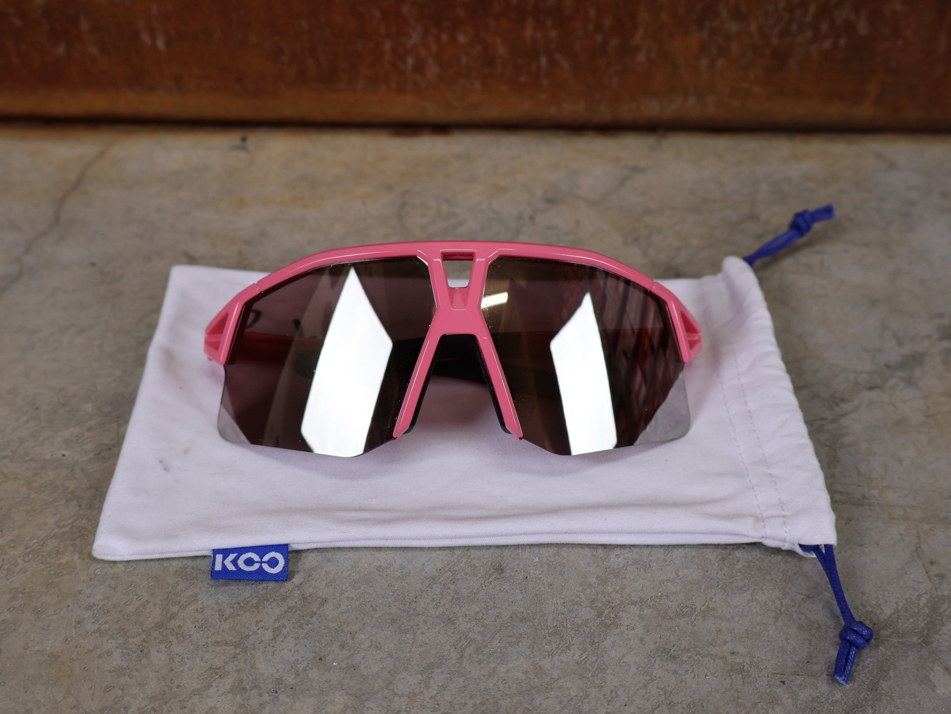 Brillen von Koo, KOO RED BULL - BORA HANSGROHE HYPE SONNENBRILLE / LEADER EDITION PINK vor USEDBIKES - OB.DE Hintergrund